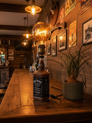 Lampada artigianale da tavolo realizzata con bottiglia Jack Daniel’s, lampadina vintage “Love” accesa,