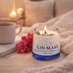 Candela Gin Mare accesa in bottiglia riciclata su tavolo in marmo in salotto moderno, decorazione casa design
