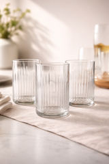 Bicchieri in vetro riciclato da bottiglie Campari Bitter su tavola apparecchiata elegante