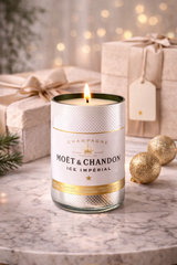 Candela Moët & Chandon in vetro riciclato accesa con confezioni regalo eleganti e dettagli oro in ambiente luminoso