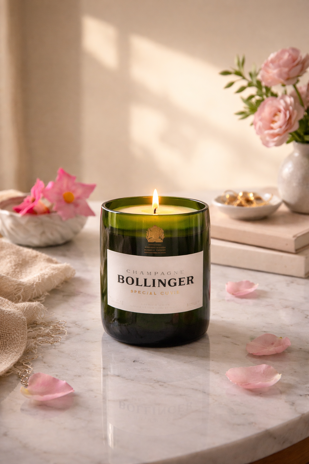 Candela artigianale in bottiglia Bollinger riciclata accesa su tavolo in marmo con fiori e luce calda in ambiente elegante