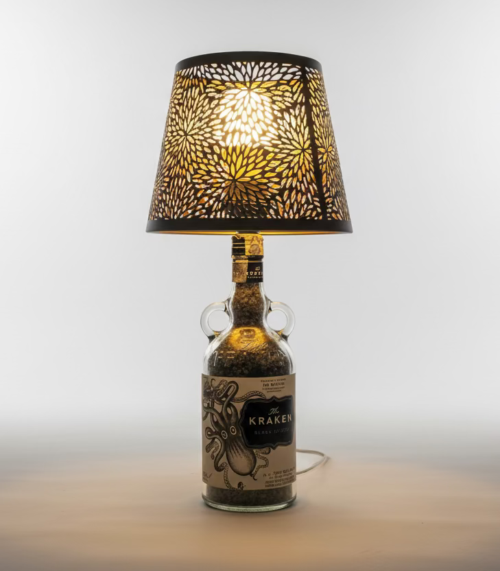 Lampada di design realizzata con bottiglia Kraken rum, paralume decorativo e luce calda, ideale per arredare salotti moderni