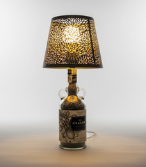 Lampada di design realizzata con bottiglia Kraken rum, paralume decorativo e luce calda, ideale per arredare salotti moderni