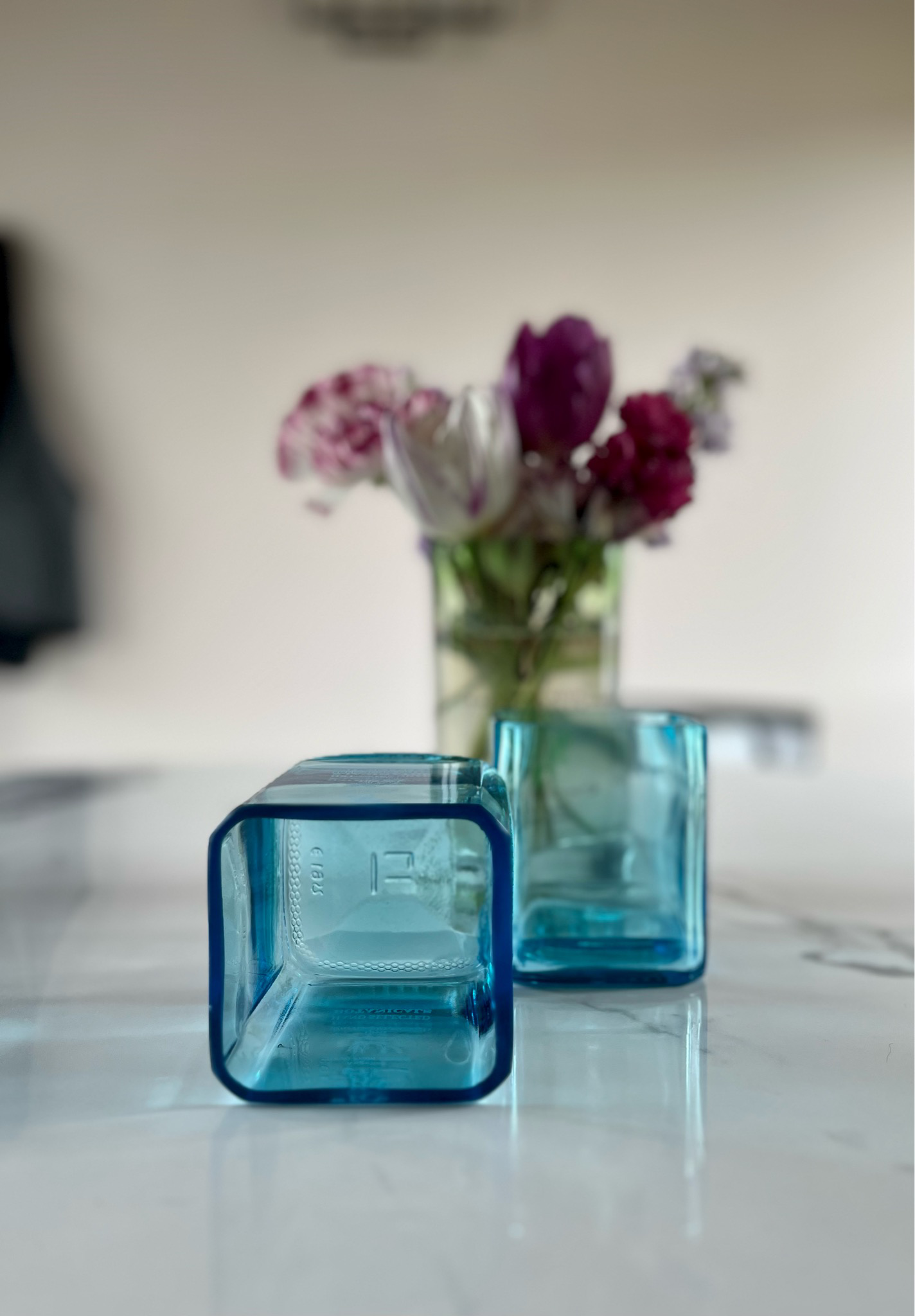 Dettaglio bicchieri in vetro blu riciclato con riflessi e texture in ambiente luminoso