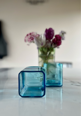 Dettaglio bicchieri in vetro blu riciclato con riflessi e texture in ambiente luminoso