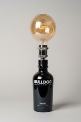 Lampada Bulldog gin con luce calda e scritta luminosa, perfetta per creare atmosfera accogliente in salotto contemporaneo