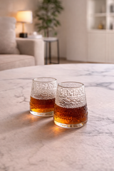 Set bicchieri da amaro in vetro lavorato, scena elegante di fine pasto con luce calda e dettagli gourmet