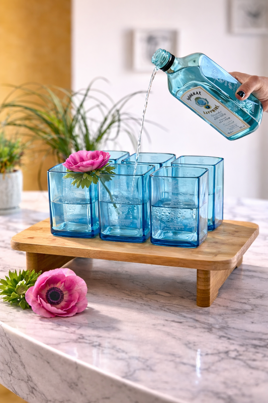 Bicchieri in vetro blu realizzati da bottiglie Bombay Gin riciclate con versata, set design sostenibile