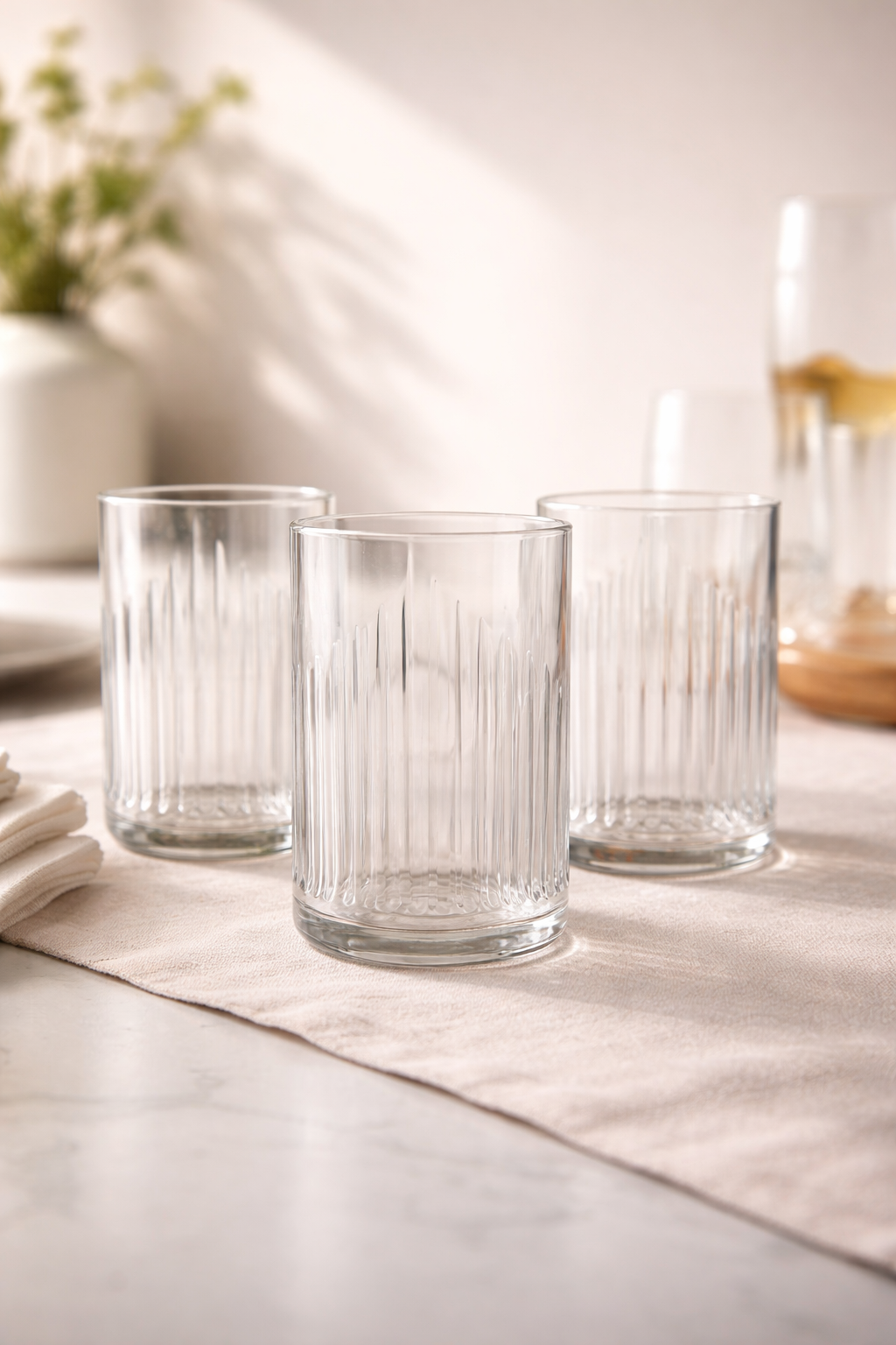 Bicchieri in vetro riciclato da bottiglie Campari Bitter su tavola apparecchiata elegante