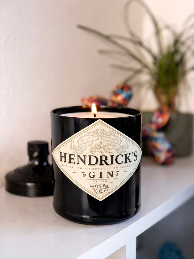 Dettaglio candela Hendrick’s Gin in vetro riciclato con etichetta originale e fiamma accesa