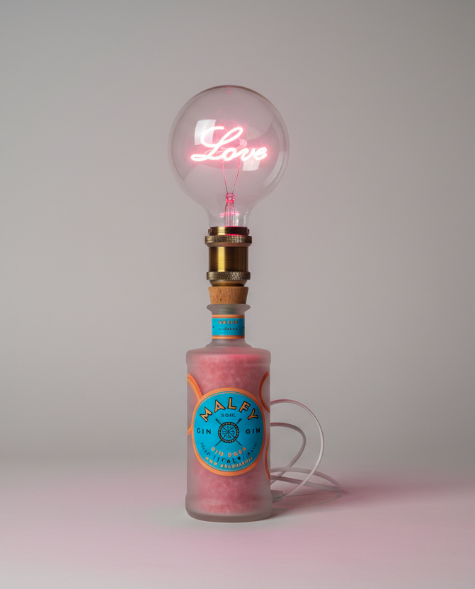 Lampada Malfy rosa personalizzata con scritta love in led rosa, realizzata a mano da bottiglia di Malfy.